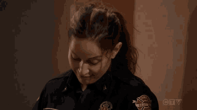 a woman in a firefighter uniform is smiling and looking up