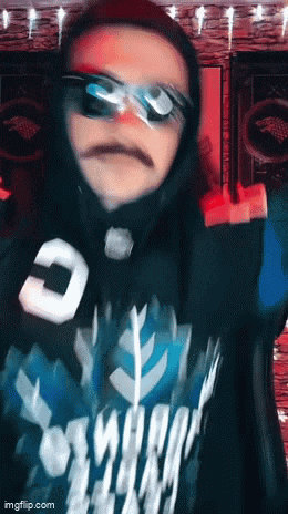 a blurry picture of a person wearing sunglasses and a shirt that has the letter c on it