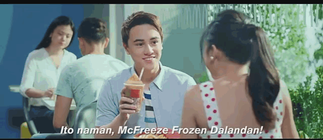 a man and a girl are sitting at a table and the girl says " ito naman mcfreeze frozen dalandan "