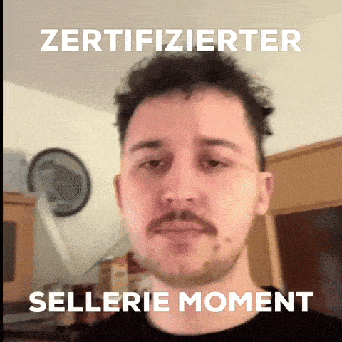 a man with a beard and mustache is standing in front of a sign that says zertifizierter sellerie moment