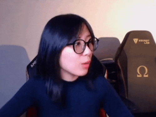 a woman wearing glasses sitting in front of a secret lab chair