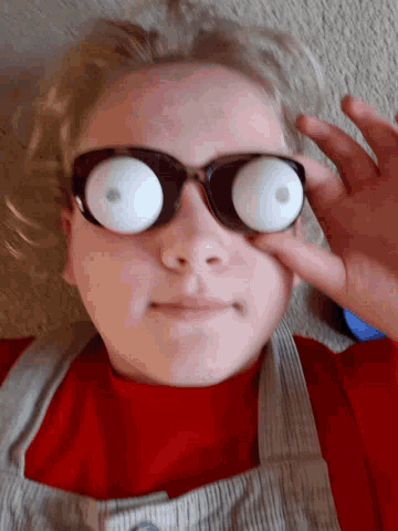 a person wearing glasses that look like eggs on their eyes