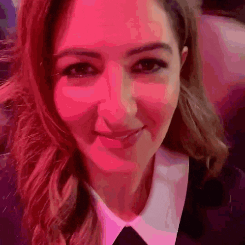 a close up of a woman 's face with a pink background