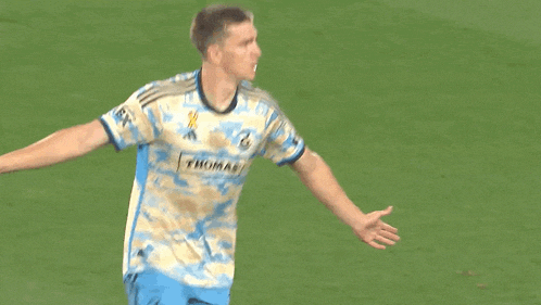 a soccer player wearing a camouflage jersey with the word thomas on the front