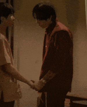 a man in a red shirt shakes another man 's hand