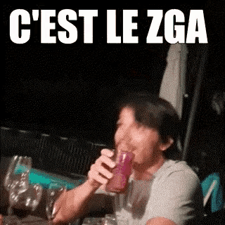 a man is drinking a drink from a glass with the words c ' est le zga written on it .
