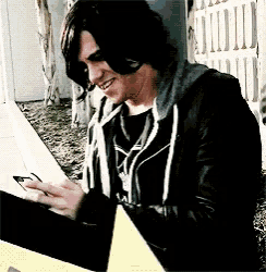 a man in a black jacket is looking at his phone