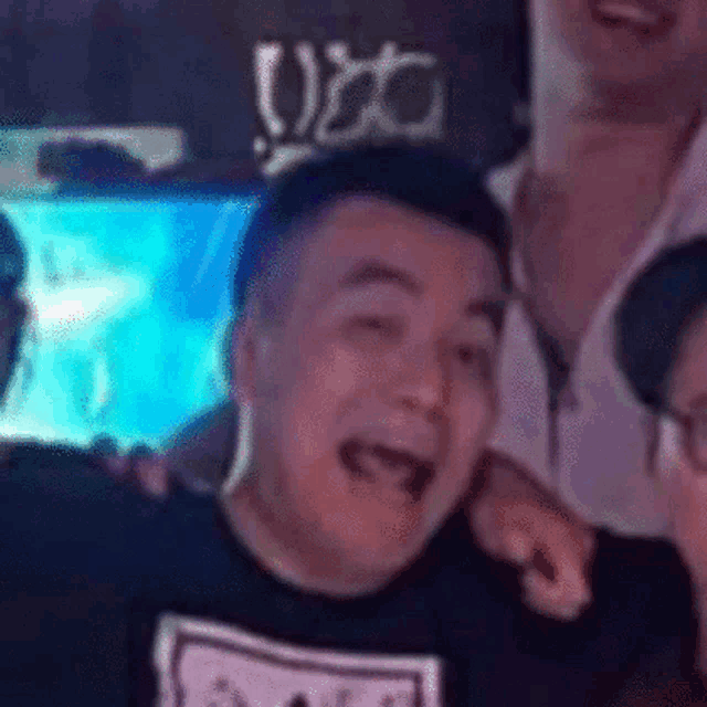 a man is making a funny face while standing next to another man .