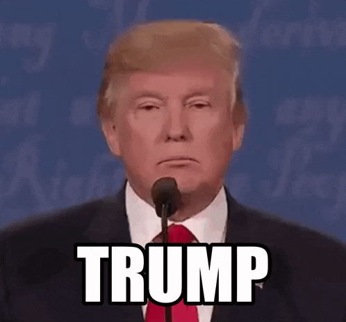 donald trump is giving a speech in front of a microphone with the word trump written on it .