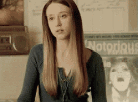 a woman with long hair is standing in front of a poster that says notorious pimping .