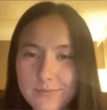 a close up of a woman 's face making a funny face while looking at the camera .