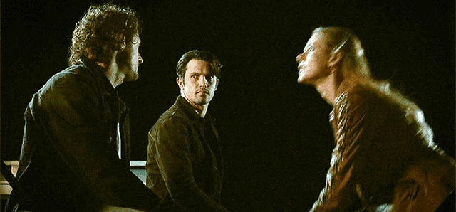 a man and a woman are standing in a dark room