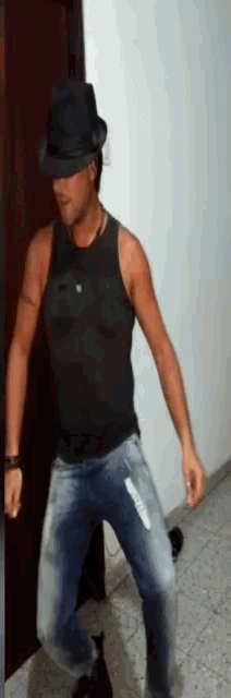 a man wearing a black tank top and a hat is dancing