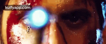 a close up of a man 's face with a blue light coming out of his eye .