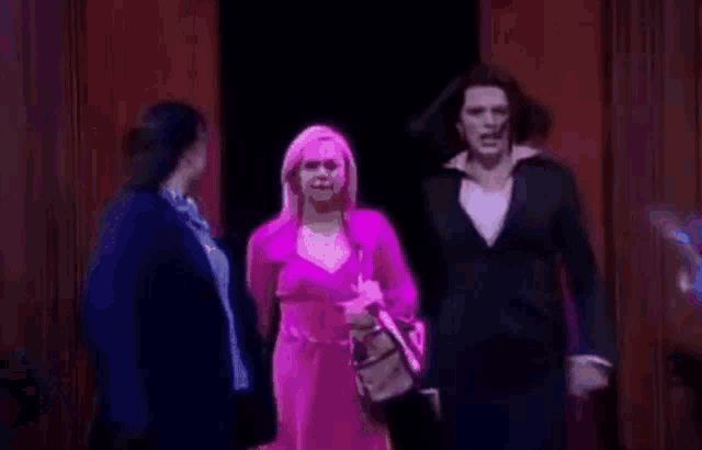 a group of women are standing on a stage in a dark room .