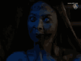 a close up of a woman 's face in a dark room with a channel 7 logo in the corner
