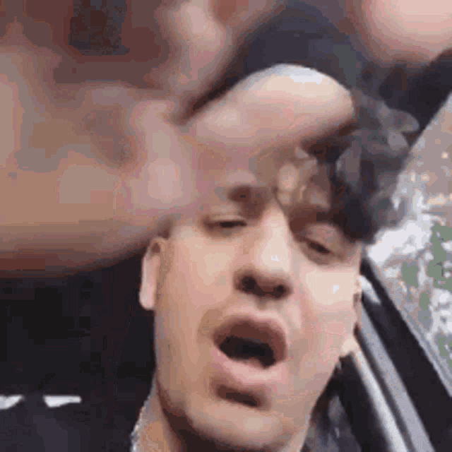 a man is making a funny face in a car .