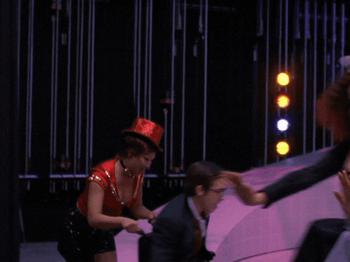 a man in a suit is being pushed by a woman in a top hat