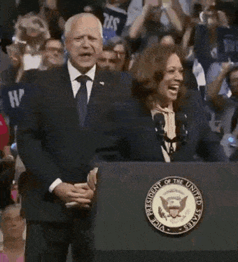 a man and a woman are standing behind a podium that says president of the united states on it .