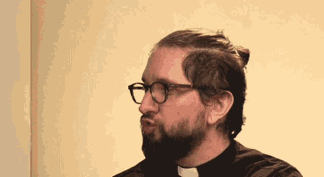 a man with a beard and glasses is wearing a black shirt