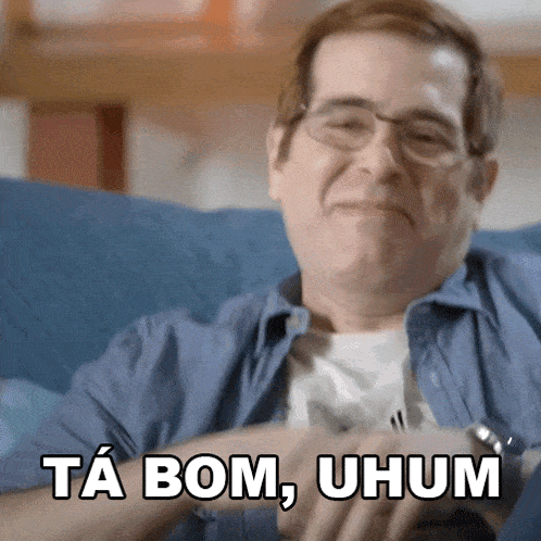 a man sitting on a couch with the words ta bom uhum written on his face