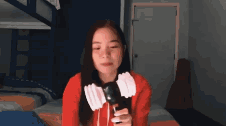 a woman in a red sweater is holding a microphone