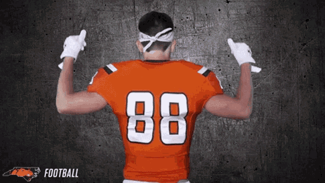 a football player wearing an orange jersey with the number 88 on it