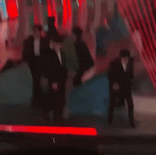 a group of men in suits and bow ties are standing in front of a laser beam