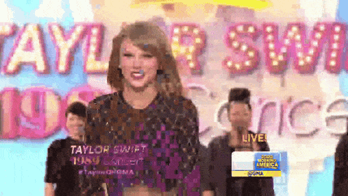 taylor swift is standing in front of a large sign that says taylor swift
