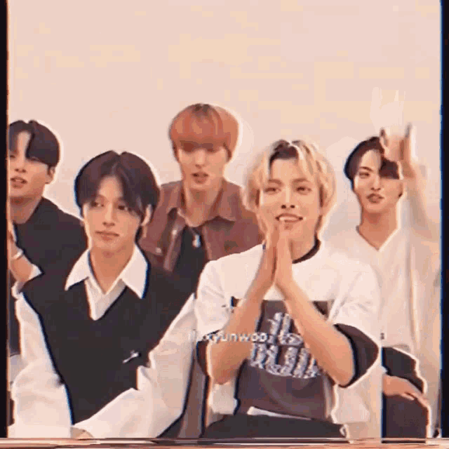 a group of young men are sitting next to each other in a room .
