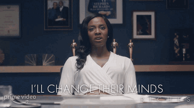 a woman sitting at a desk with the words i 'll change their minds
