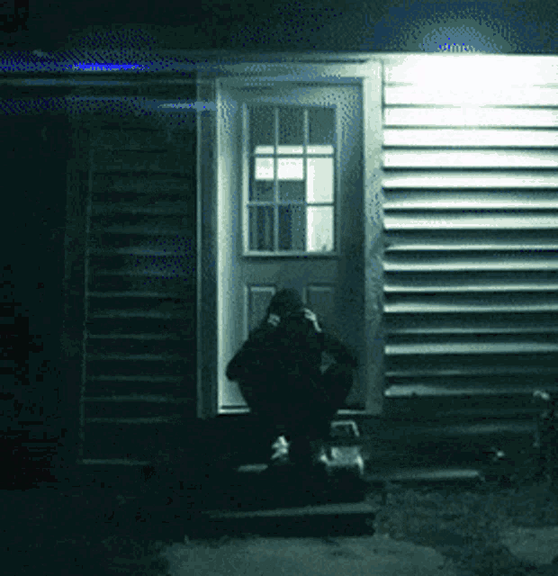 a person sitting on the steps of a house with their head down