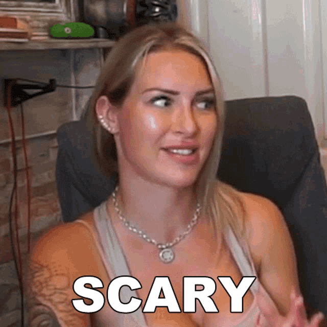 a woman is sitting in a chair with the word scary written on her chest