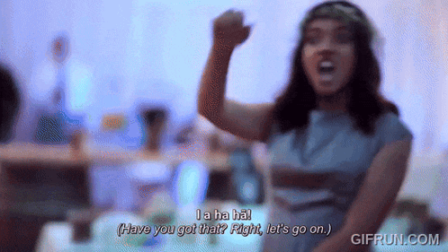 a woman in a blue dress with a flower crown on her head says " la ha ha "