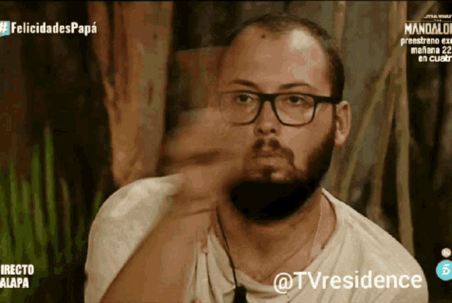 a man with glasses and a beard is on a tv screen