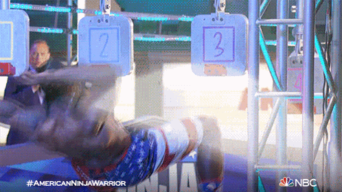 a person is doing a handstand in front of a sign that says nbc