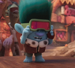 a troll wearing goggles standing on a wooden table