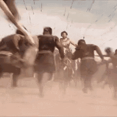 a group of people are running in the dirt while a woman is riding a horse .