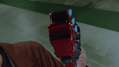 a close up of a person holding a red and black toy