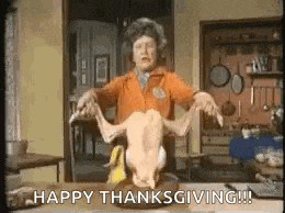 a woman is holding a dead turkey on a table and says `` happy thanksgiving ! ''