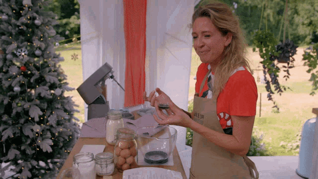 a woman wearing an apron that says ' candy cane ' on it is preparing food