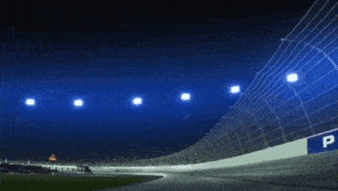 a race track is lit up at night with a lot of lights on it .