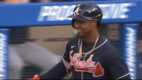 a man wearing an atlanta braves jersey and a helmet