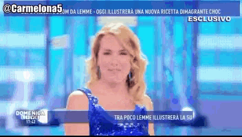 a woman in a blue dress is on a television screen with a blue background