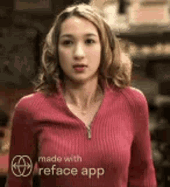 a woman in a red sweater is standing in front of a building and looking at the camera .