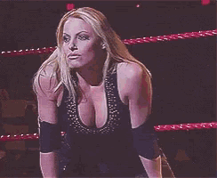 a woman in a black top is standing in a ring