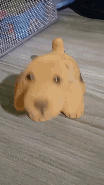 a stuffed dog laying on a wooden table