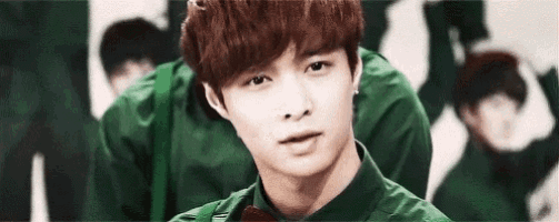 a young man with red hair is wearing a green shirt and a red bow tie .