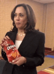 a woman in a suit is holding a bag of doritos chips
