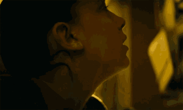 a close up of a person 's face with a yellow light behind her